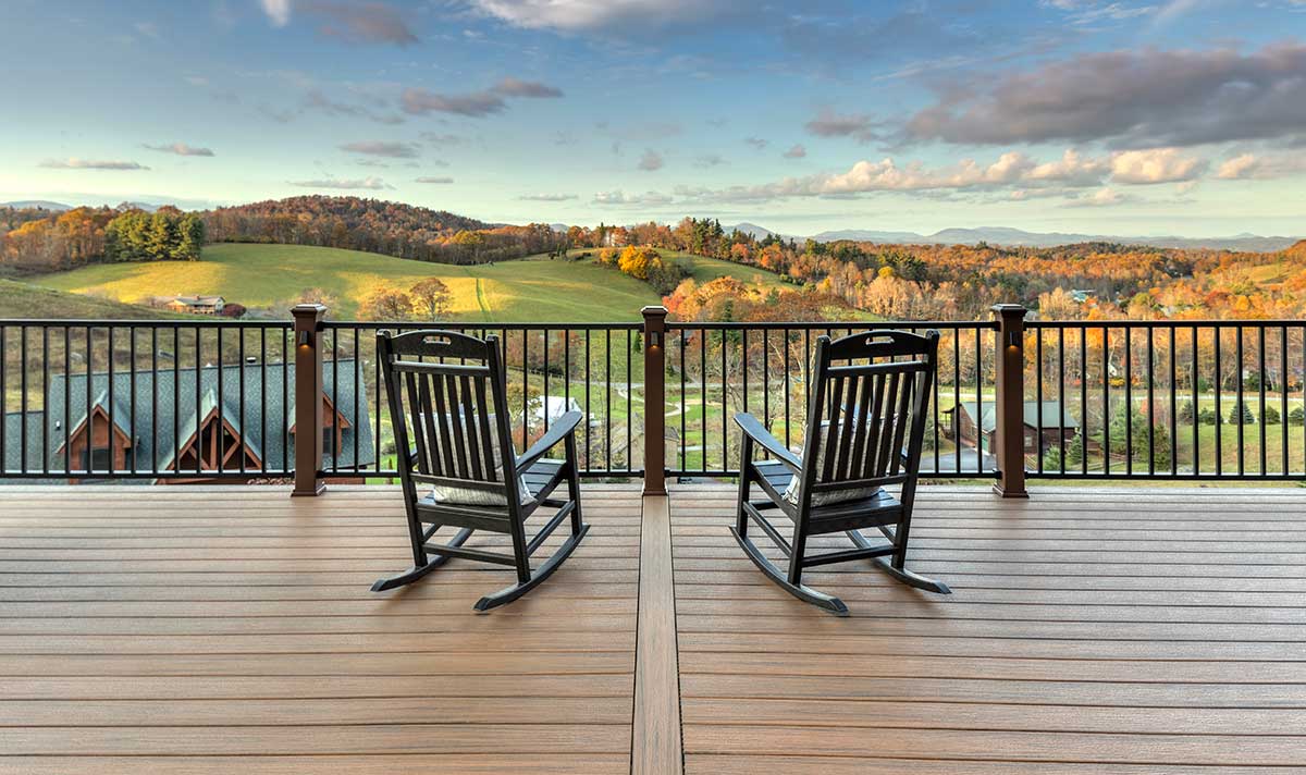 Two rocking chairs on a deck with Trex railing overlooking golf course