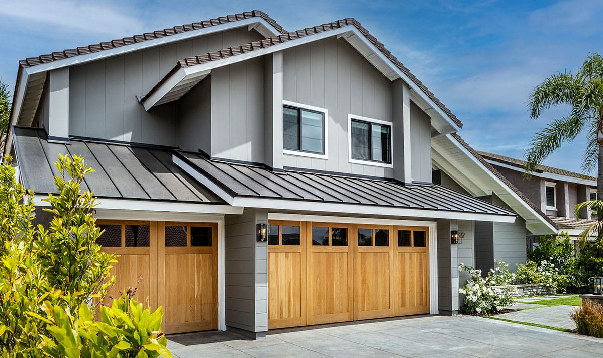 Closeup of two-story residential home with wooden garage door made with James Hardie panels