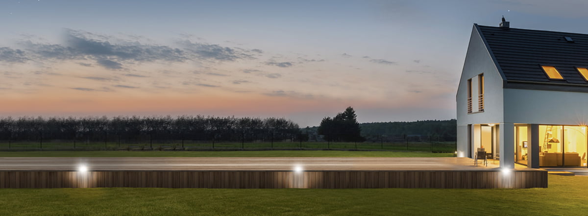 Home at dusk with a large deck made of PWT premium engineered wood