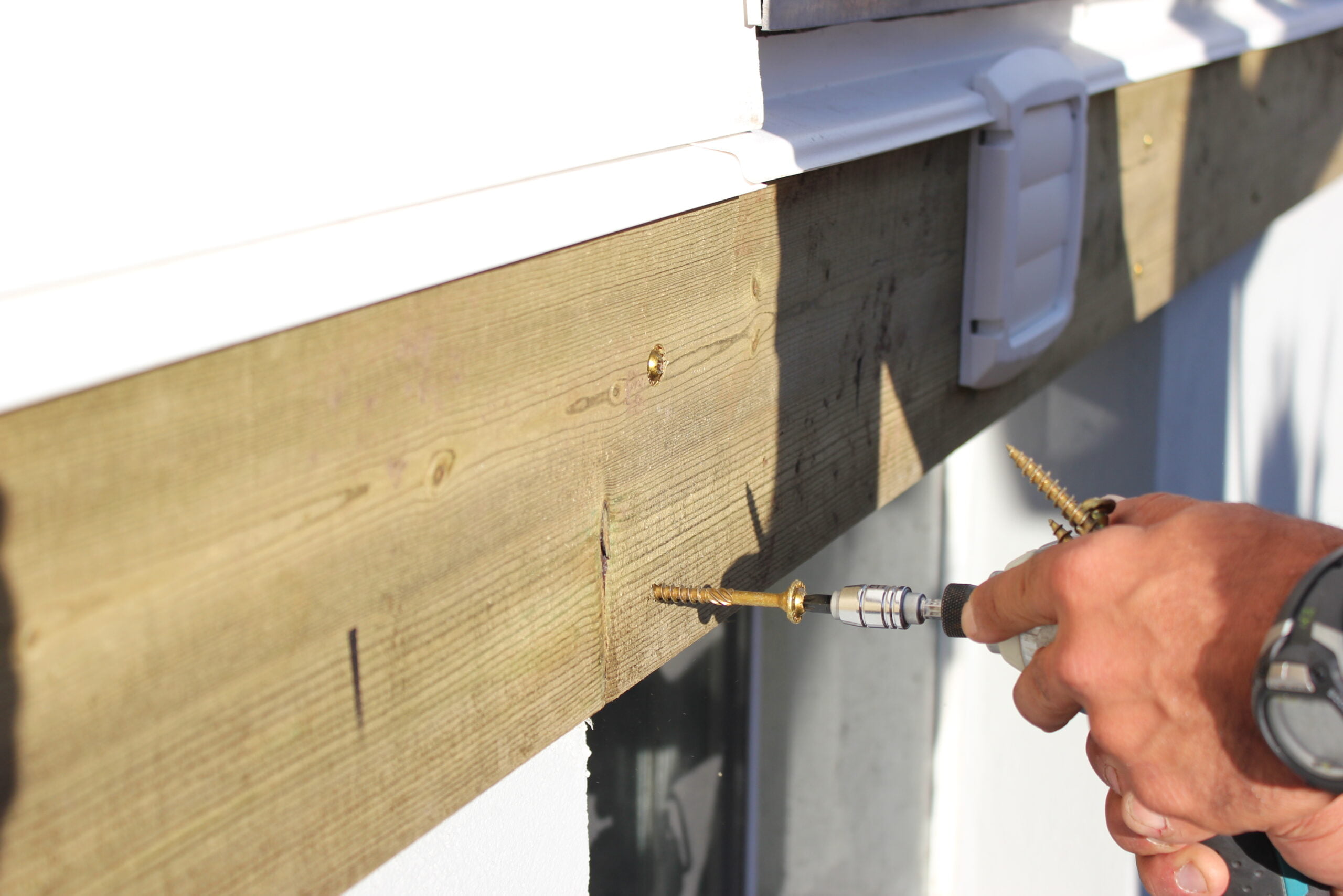 Closeup of person drilling GRK Fastener screw into board
