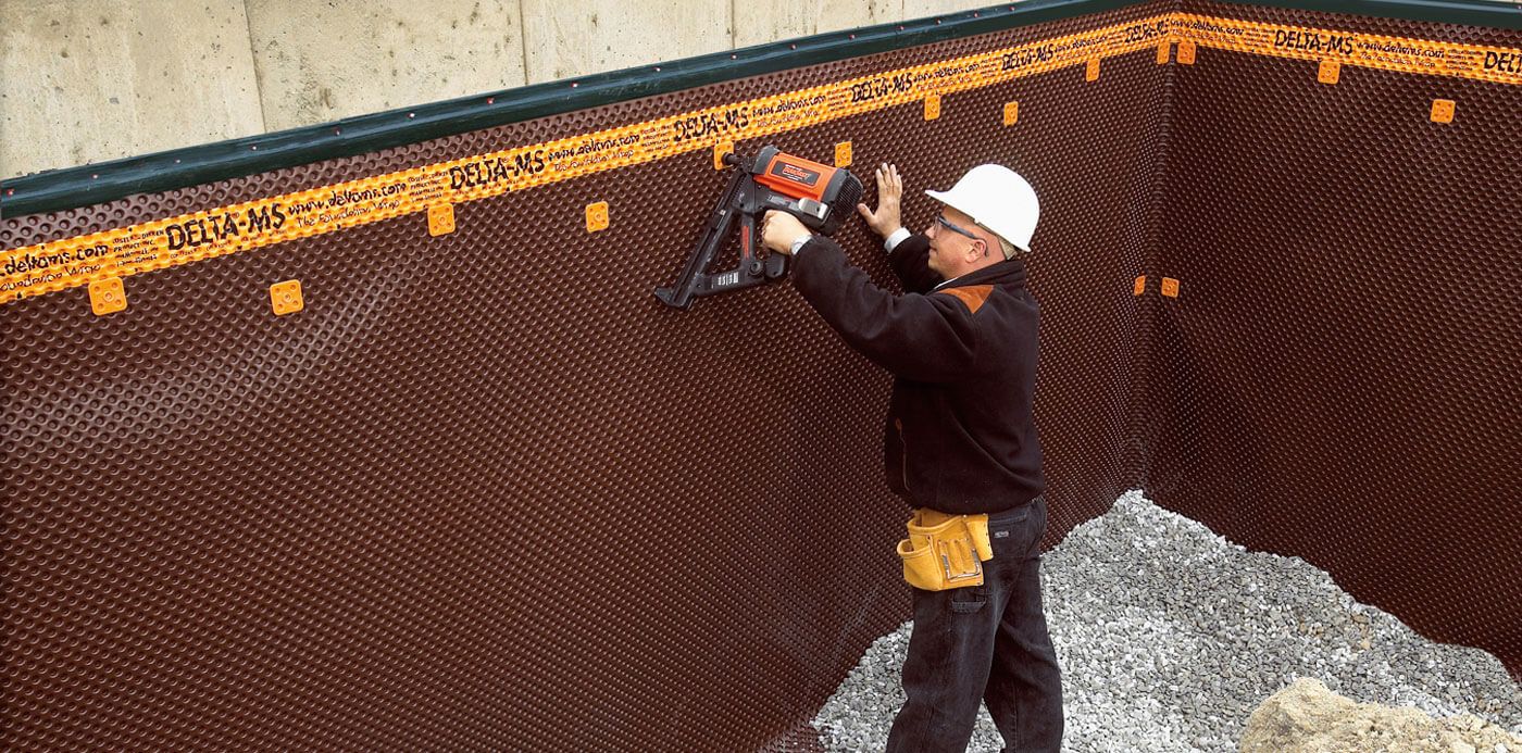man applying dorken moisture barrier