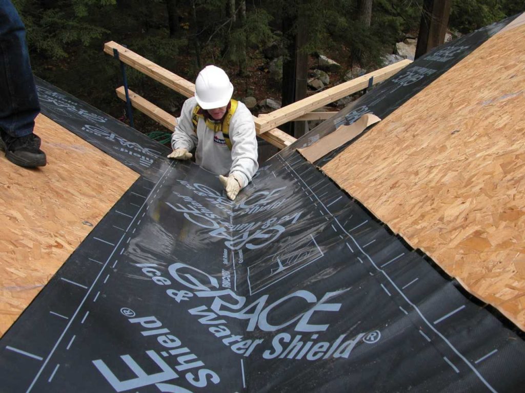 worker applies grace ice water shield to roof