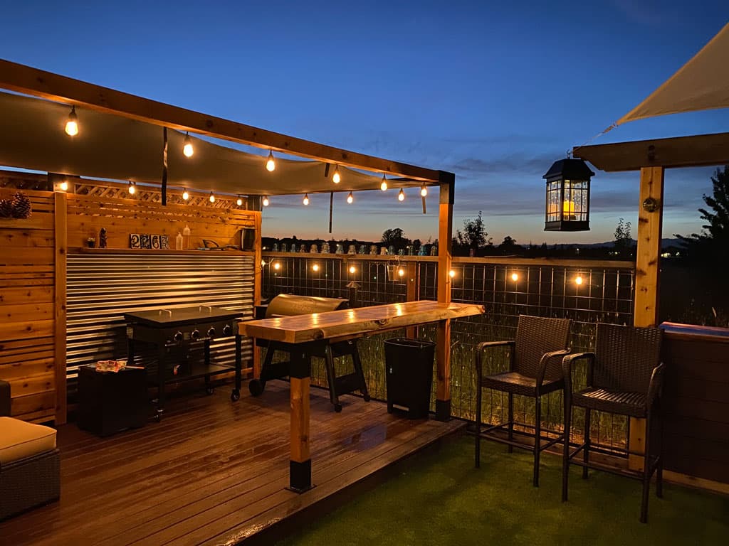 LINX pergola in backyard at dusk with lights and seating area