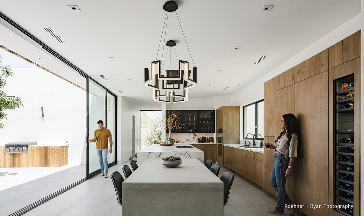 Two people standing in an open kitchen with sliding Fleetwood Windows and Doors