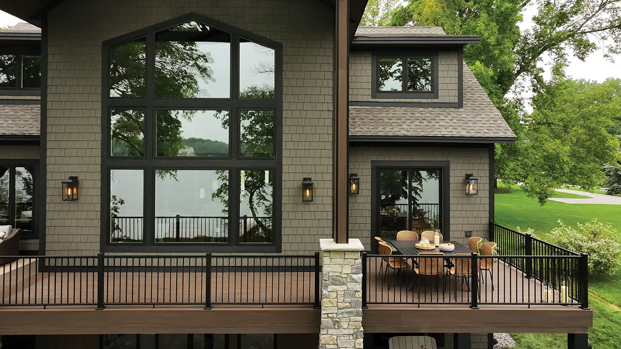 Backyard view of two story home with AZEK Exteriors shingle siding and decking in English Walnut color