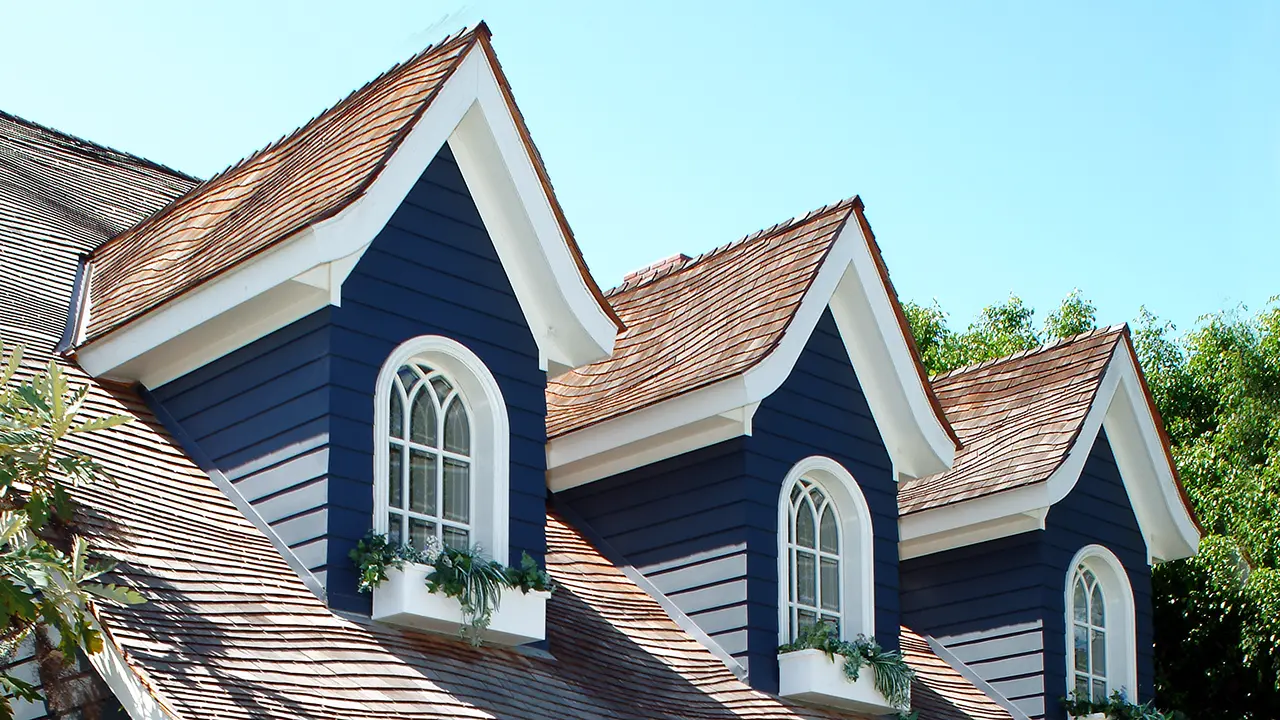 AZEK Exteriors trim moulding on three second story dormer windows in navy blue