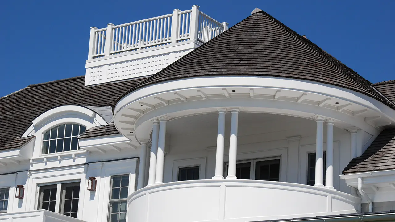 White and gray coastal home with round turret using AZEK Exteriors trim moulding in white