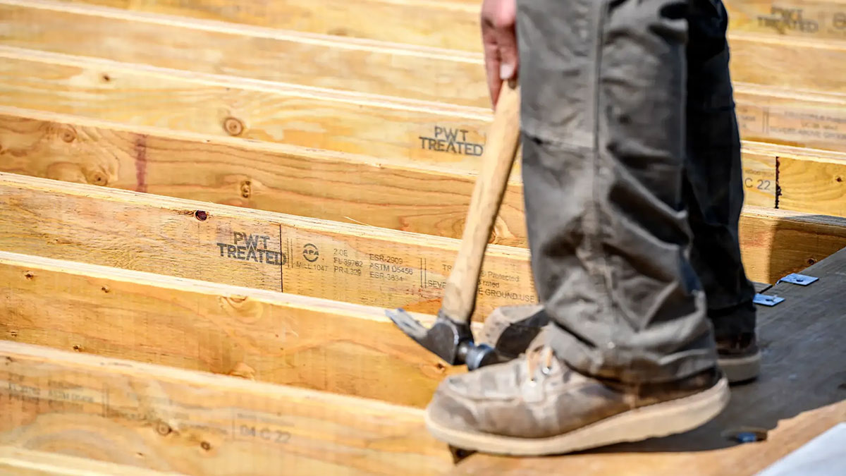 Closeup of worker hammering PWT I-Joist