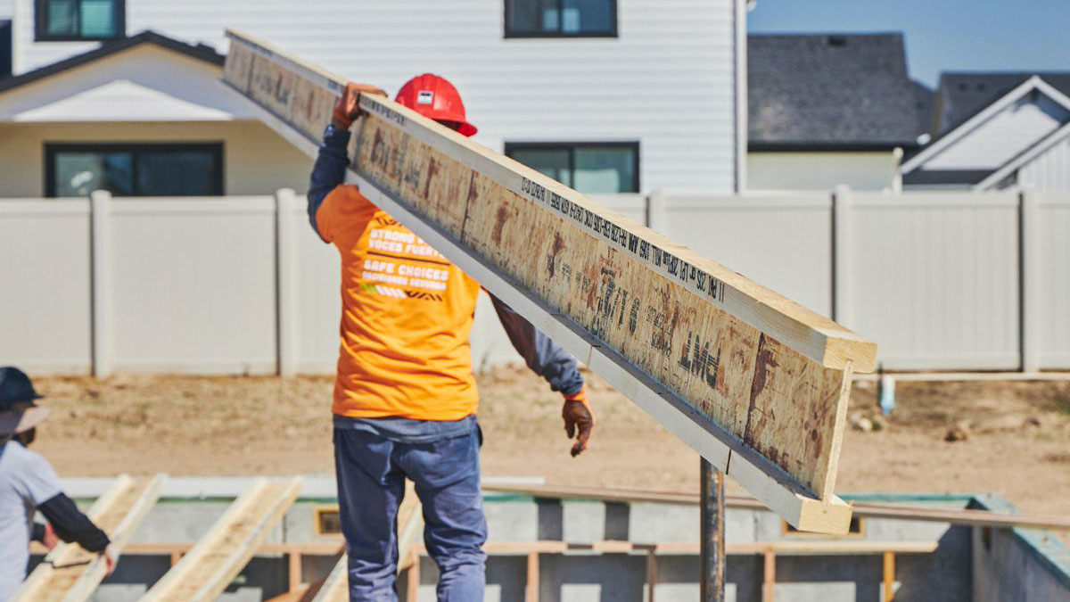 Contractor carrying PWT I-Joist on job site