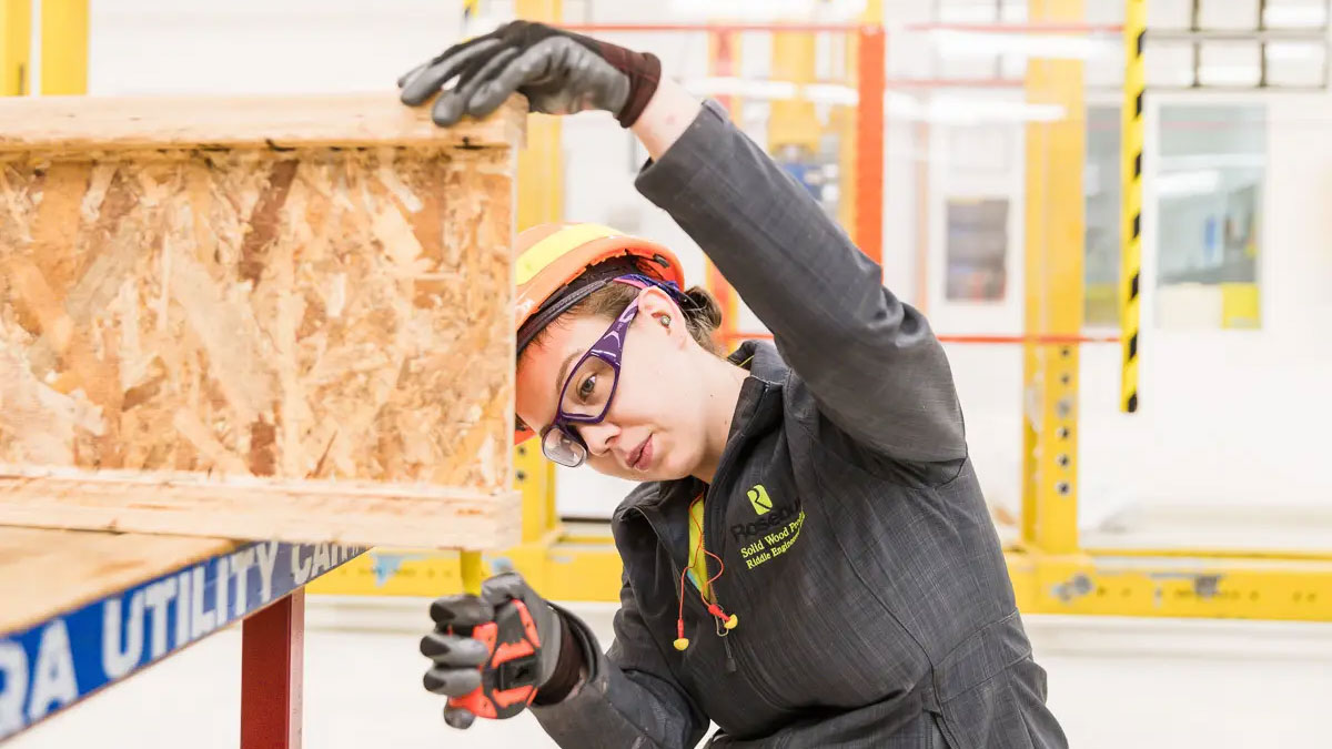 Roseburg employee inspecting engineered wood