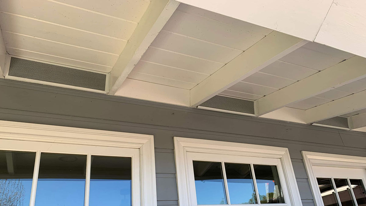 Underawning view of Vulcan Vent eave vents on a gray home