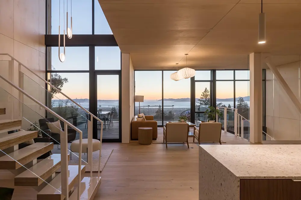Living room and kitchen inside a Sausalito hillside home with a bay view through Western Architectural Openings windows